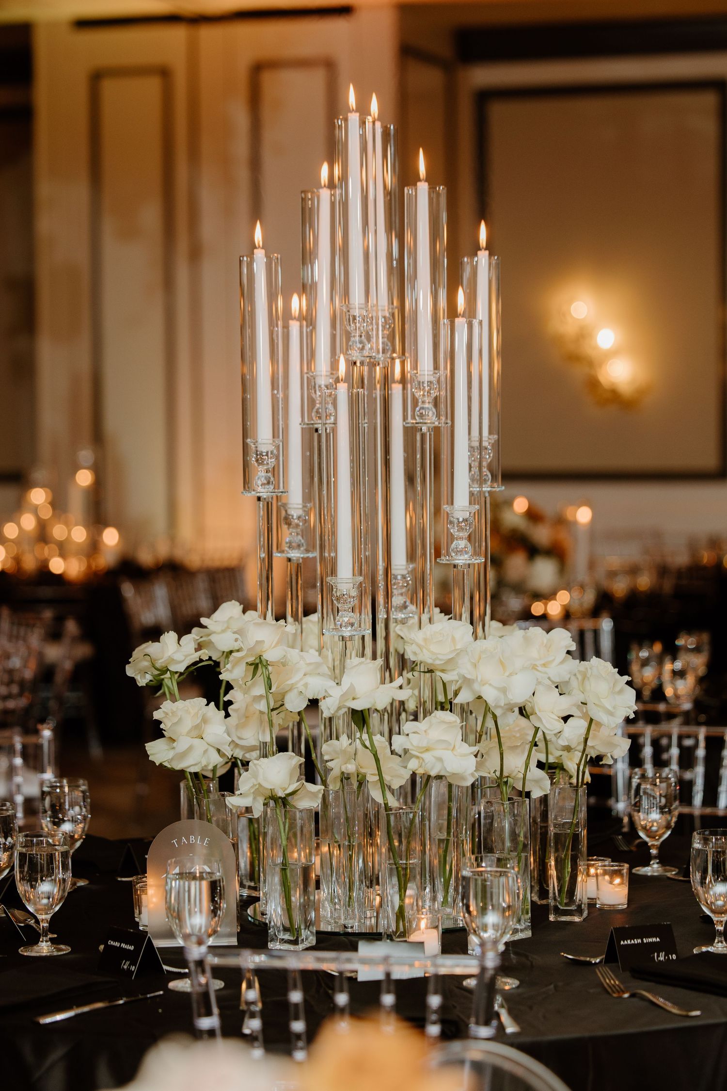 Luxurious wedding reception centerpieces featuring tall crystal candelabras and white floral arrangements.