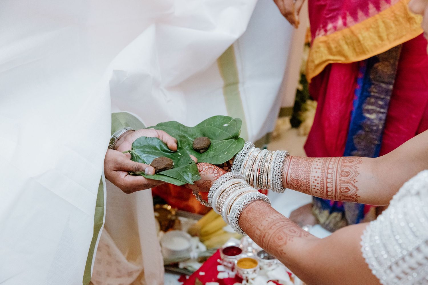 Traditional Indian wedding mehndi ceremony showing intricate henna designs being applied to hands.