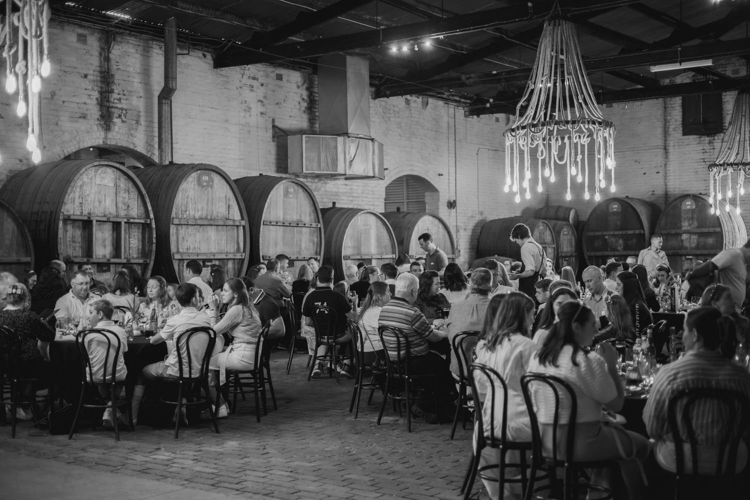 Black and white photographs show diners seated at tables in an elegant vintage restaurant setting with chandelier lighting.