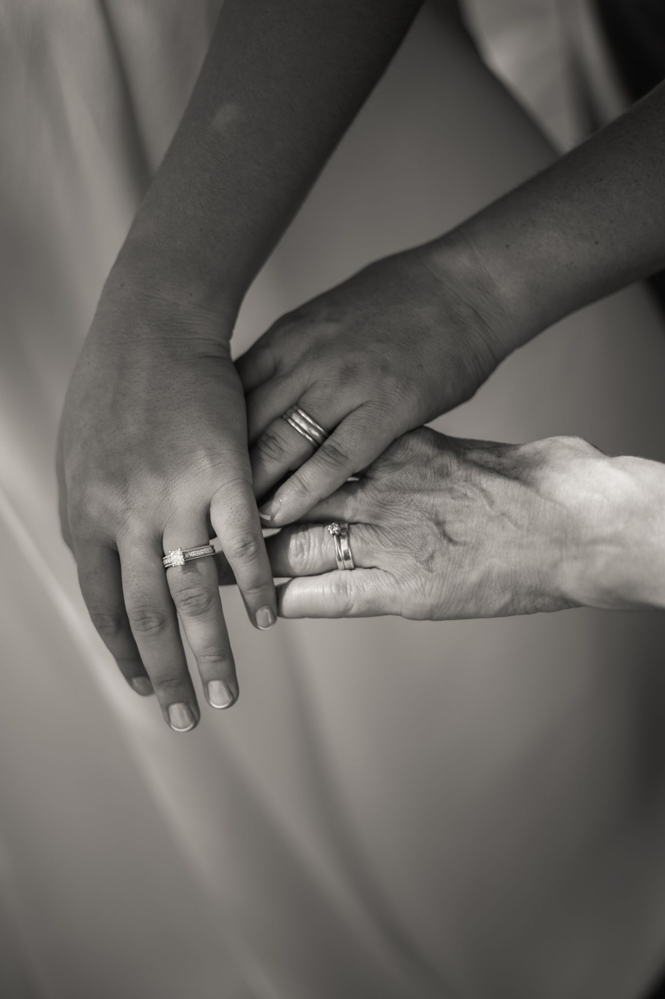 Black and white close-up sequence of hands gently holding and releasing another person's arm in an artistic style showing generations.