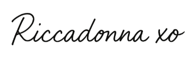 A handwritten signature in black ink appears on a white surface.