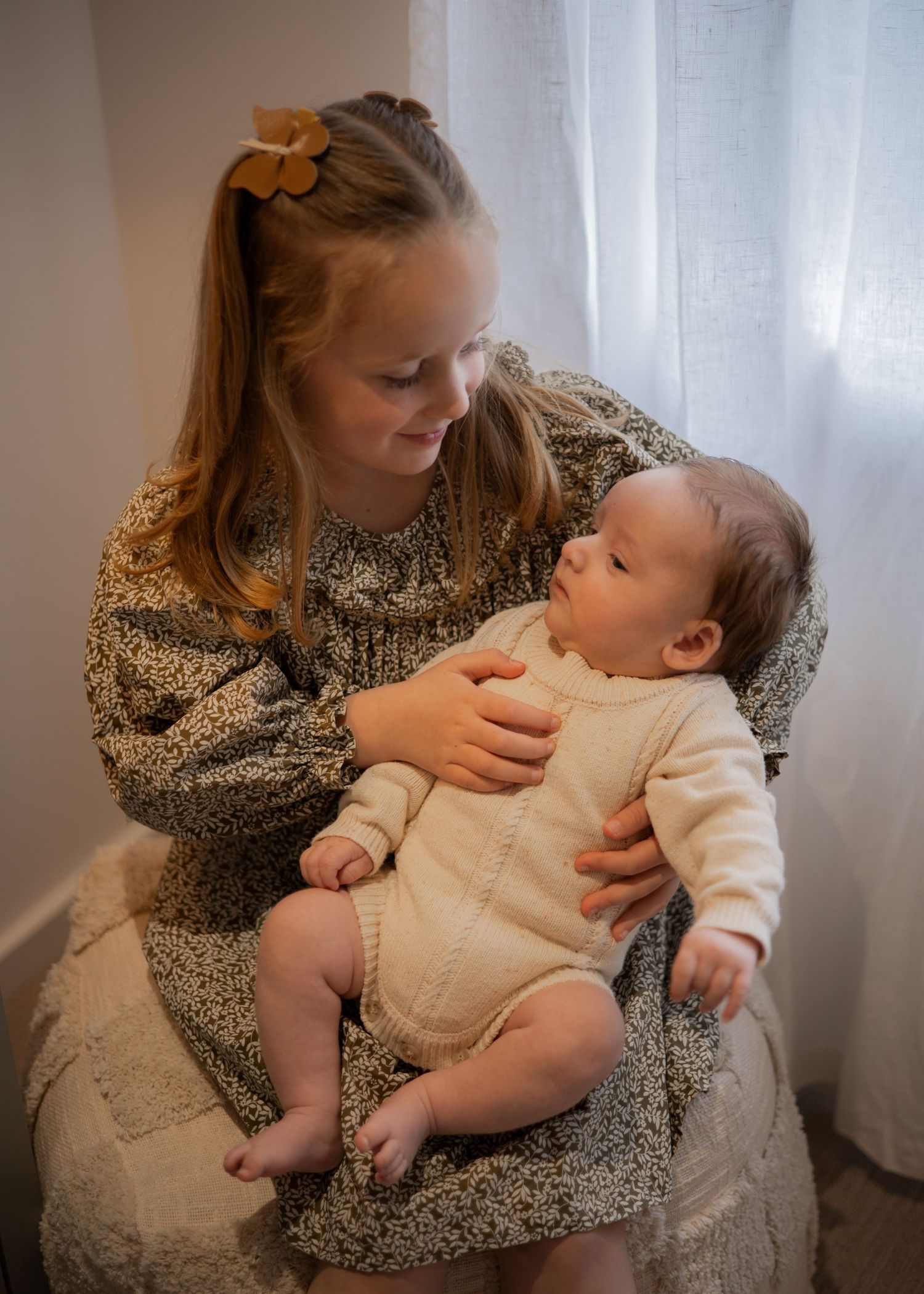 A series of tender parenting moments showing nap time comfort and snuggles between a young child in white and adult in floral dress.