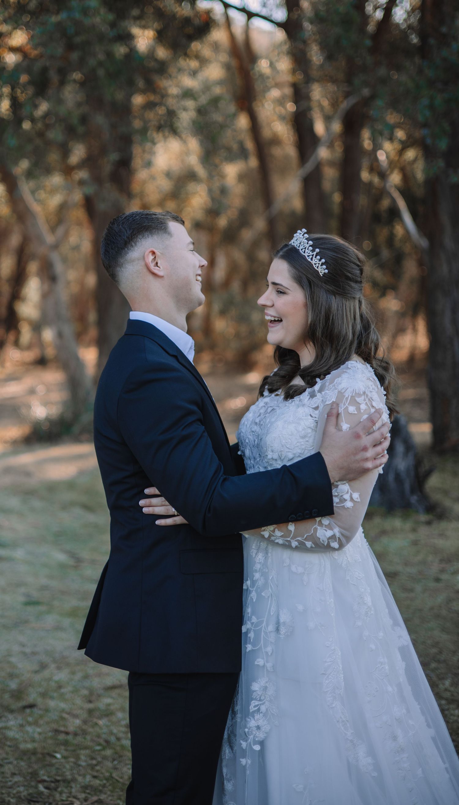 A couple shares intimate moments during their outdoor forest wedding photoshoot in formal wedding attire.