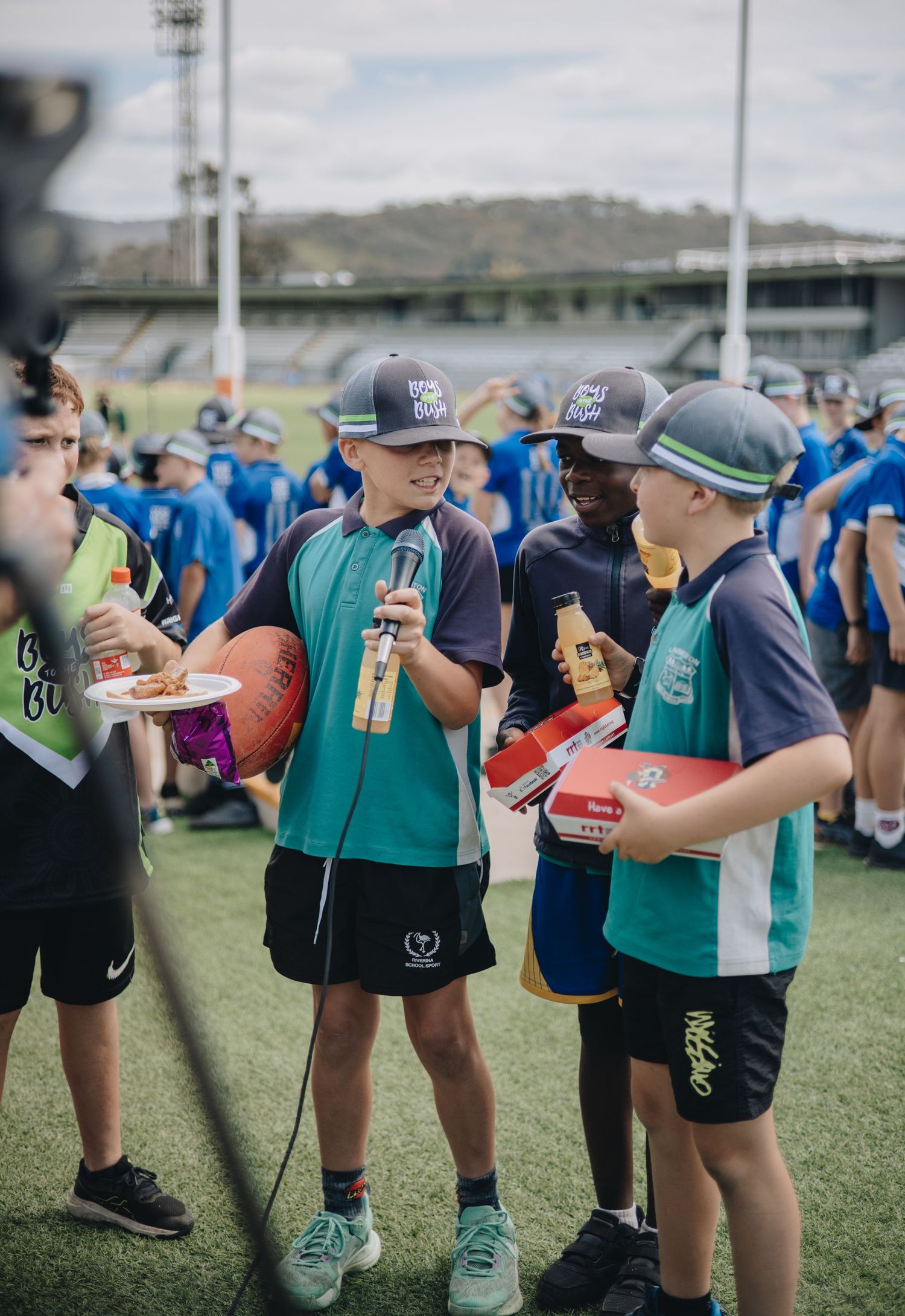 Athletes in matching uniforms gather in a line on a sports field during a training session.