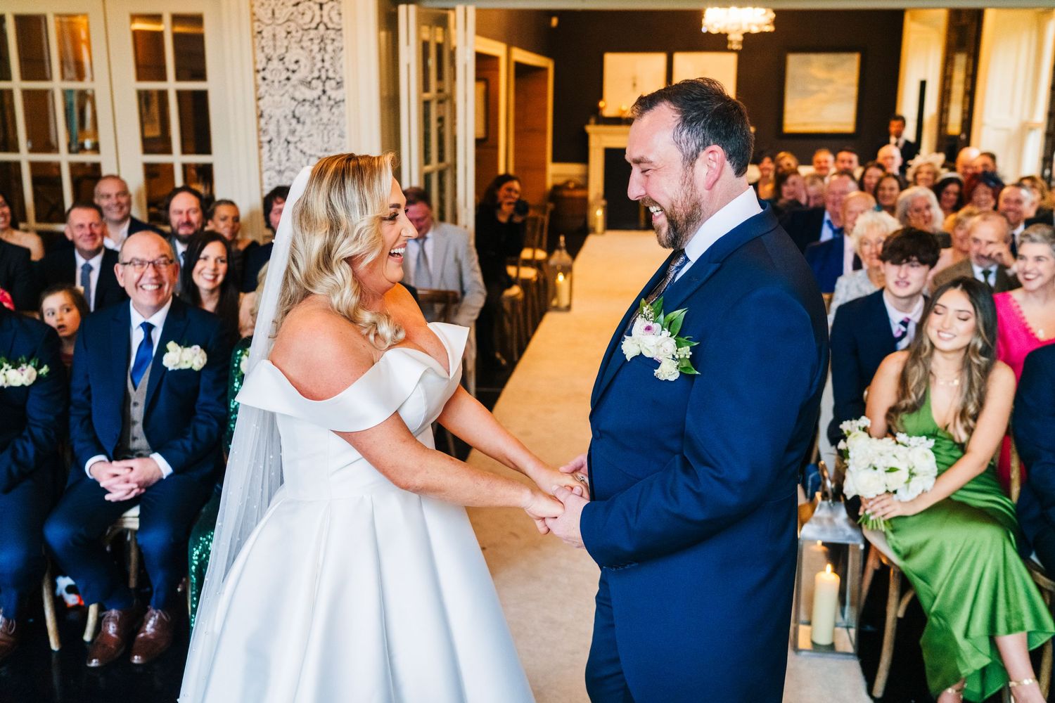 Wedding guests gather in an elegantly decorated ballroom for a celebration.  Virginia Park Lodge Wedding Photographer Cavan Dublin Ireland