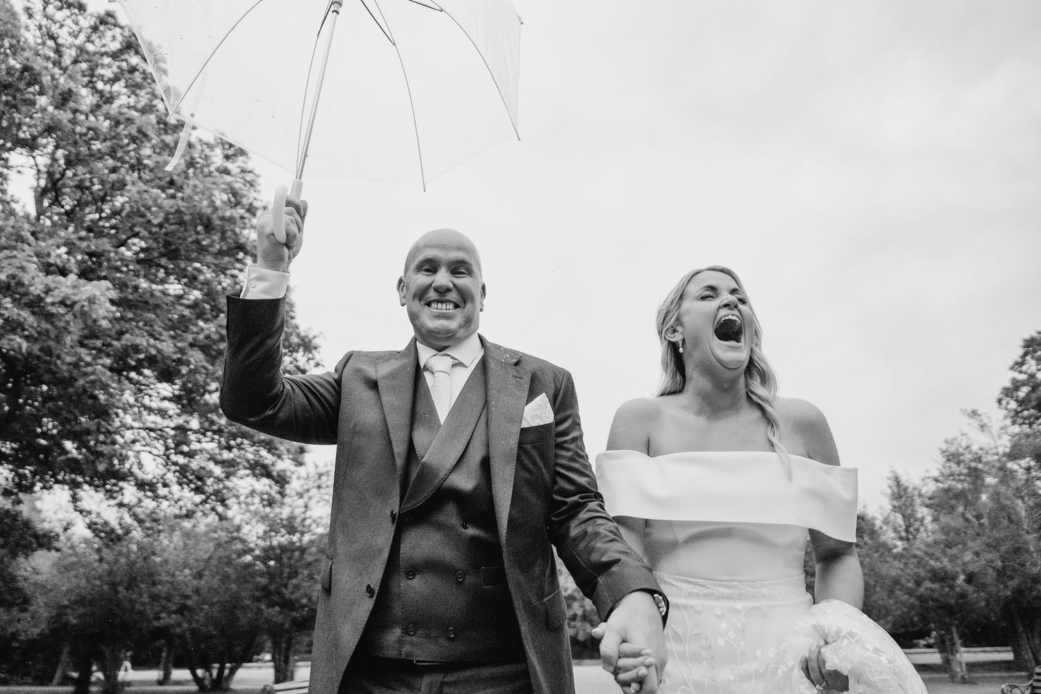 Wedding guests laughing and enjoying outdoor celebration under overcast sky. The Dean Dublin Wedding Photographer