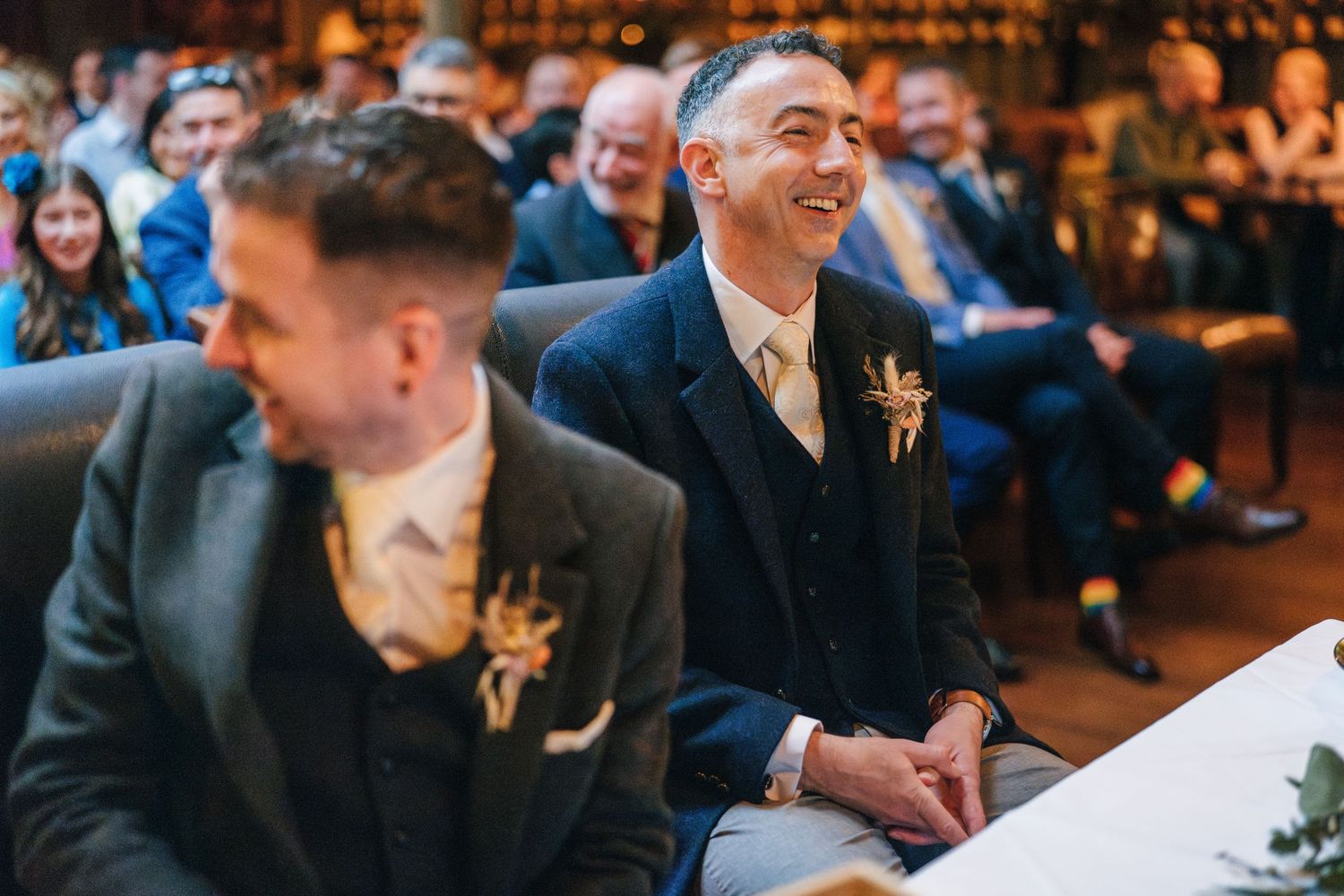 A candid moment at an indoor event with people socializing and mingling in a warm-lit venue.