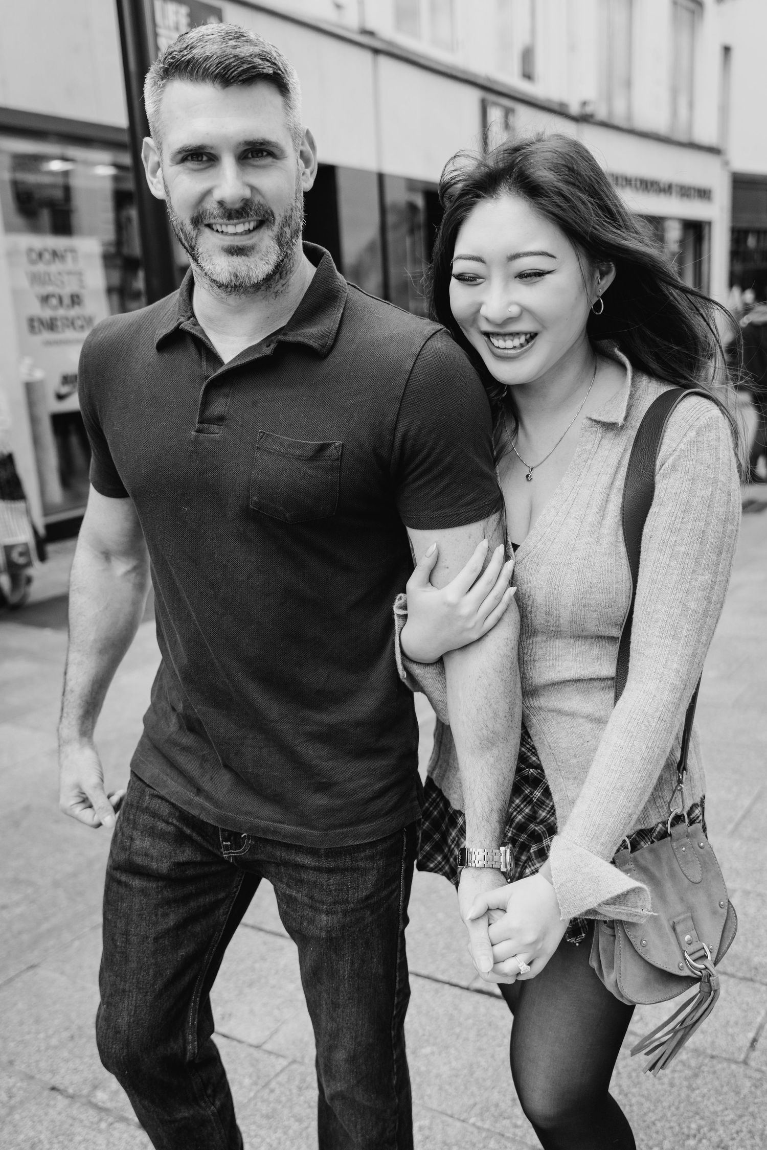 Black and white photo series showing a couple laughing and playfully posing together on a city street. PHOTOGRAPHER Dublin ireland