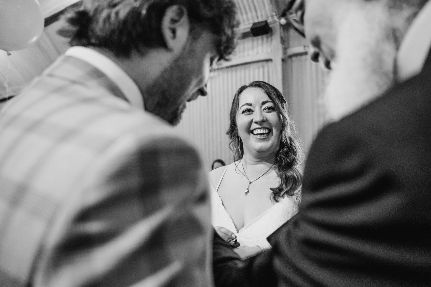 Candid black and white photo capturing laughter and joy during a wedding celebration. Wedding photographer Dublin