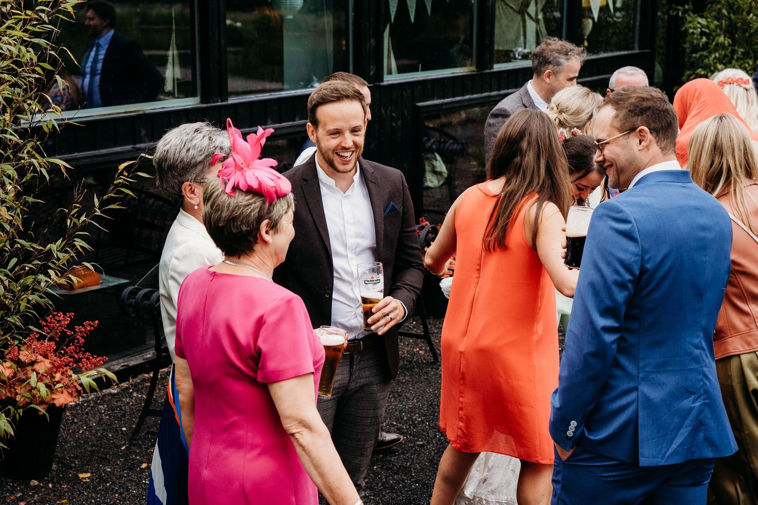 Wedding guests mingling outdoors in colorful attire during a sunny celebration. Wedding photographer Dublin