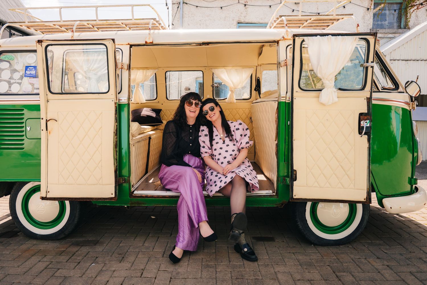 Two people sitting in a vintage cream and green VW van wearing colorful outfits. . Village Barn Tyrrellspass wedding photographer Ireland