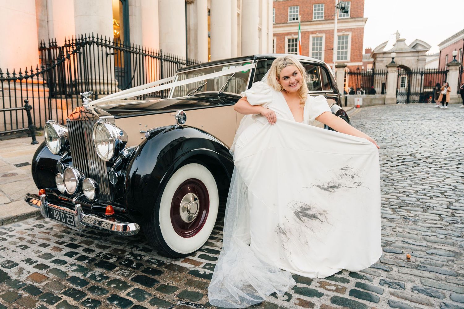 Vintage car and wedding party photographs taken on cobblestone streets with classic architecture backdrop. City Hall Dublin Photographer