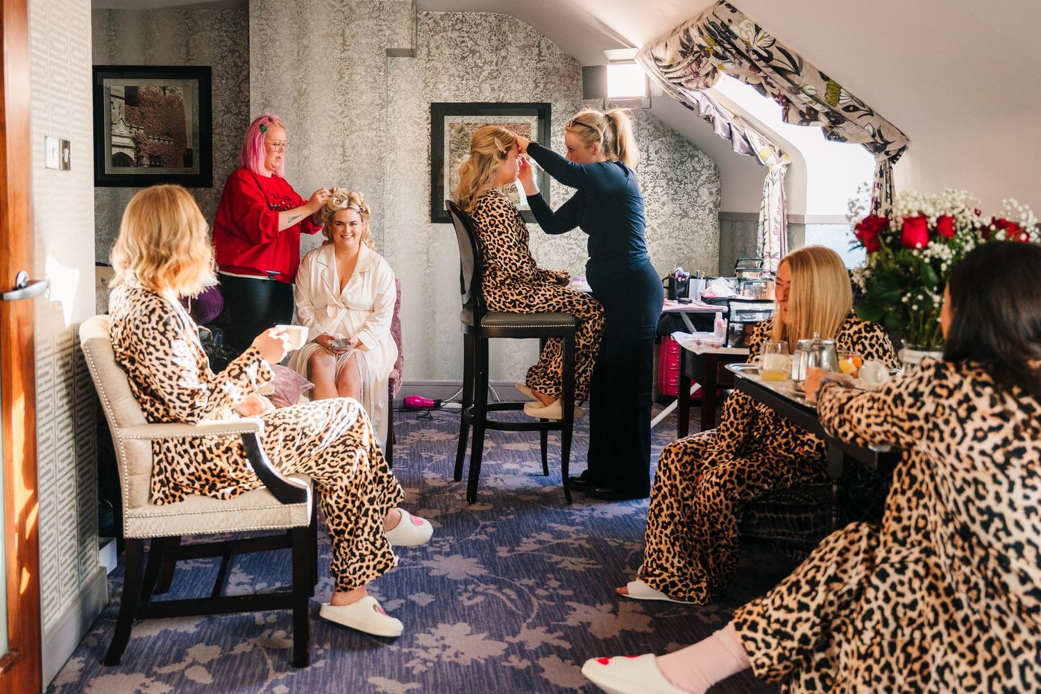 Person lounges on couch surrounded by leopard print items in a cozy living room setting.