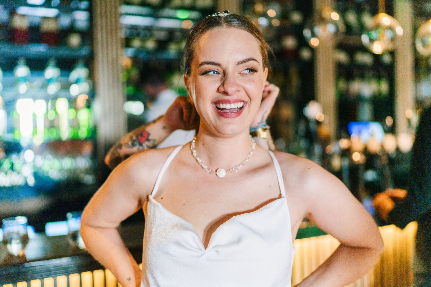 Poulaphouca Wedding photographer wicklow A cheerful woman in a white wedding dress poses at an indoor reception venue.