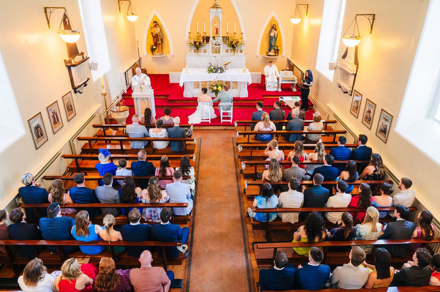 Millhouse slane wedding photographer dublin Overhead view of wedding ceremony in a traditional church with guests seated in wooden pews.