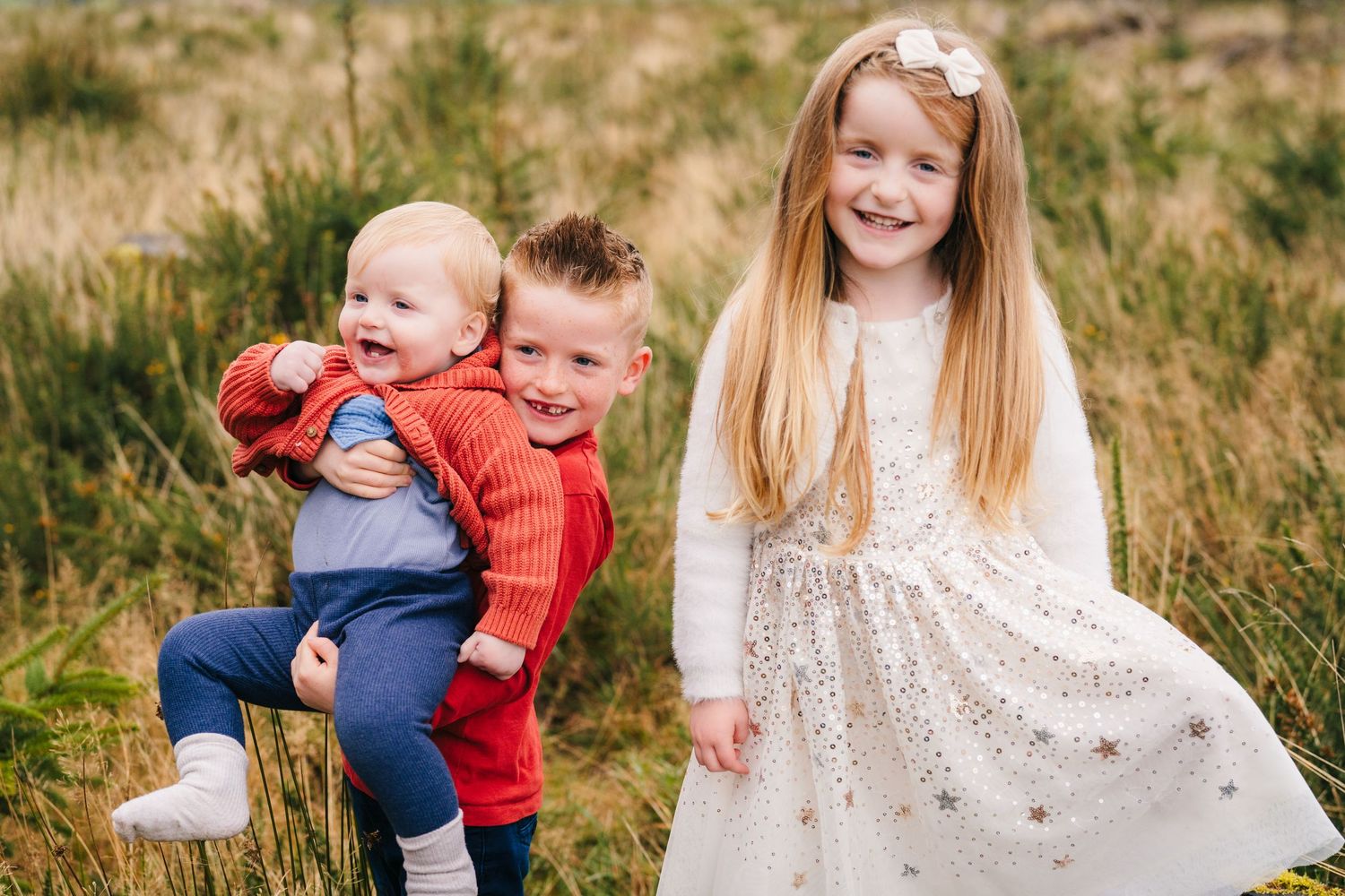 Family Photographer Dublin Ireland Playful outdoor autumn photoshoot in a grassy field with warm golden light.
