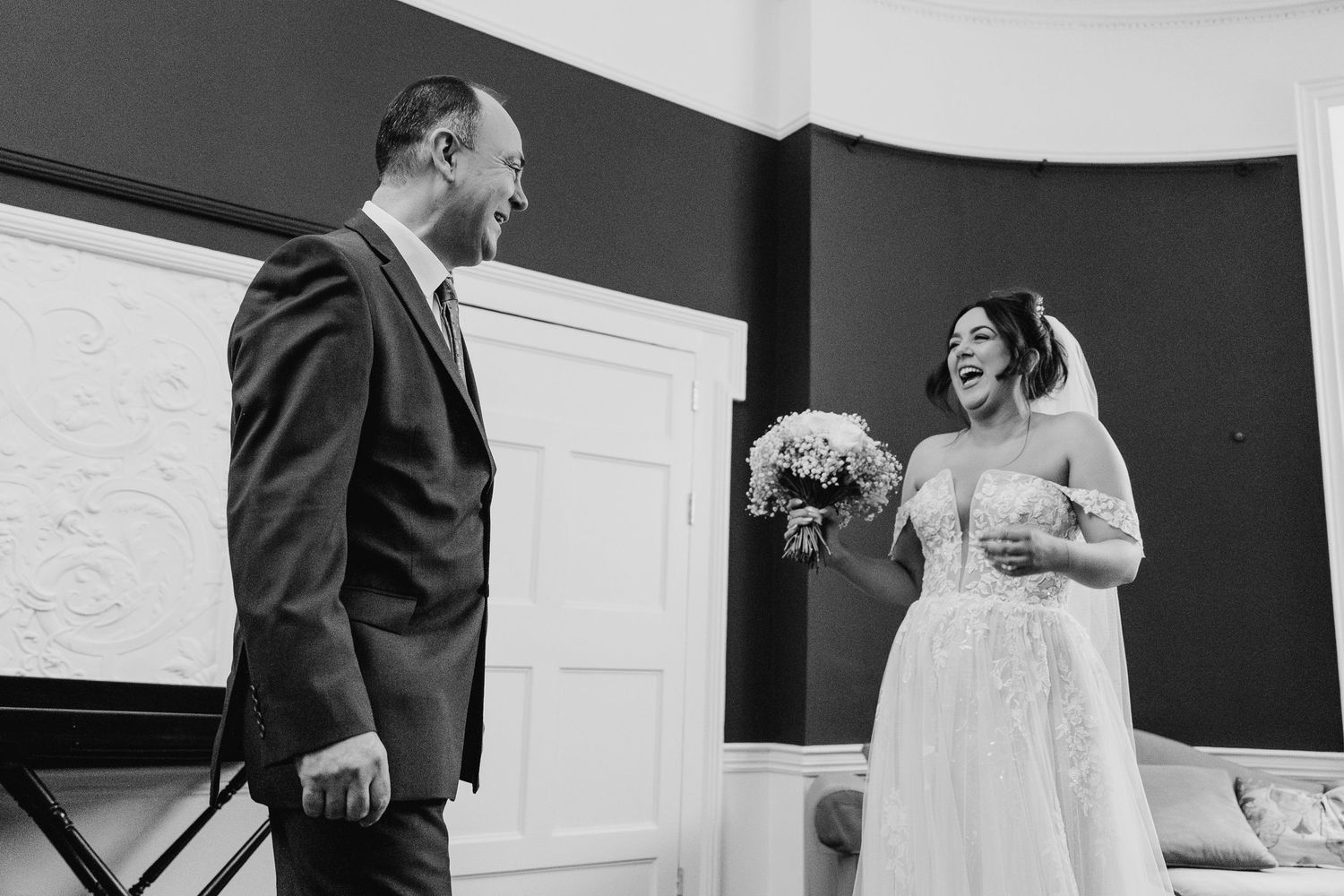A black and white photo captures a tender moment between a bride and groom during their wedding ceremony.  Wedding PHOTOGRAPHER Dublin