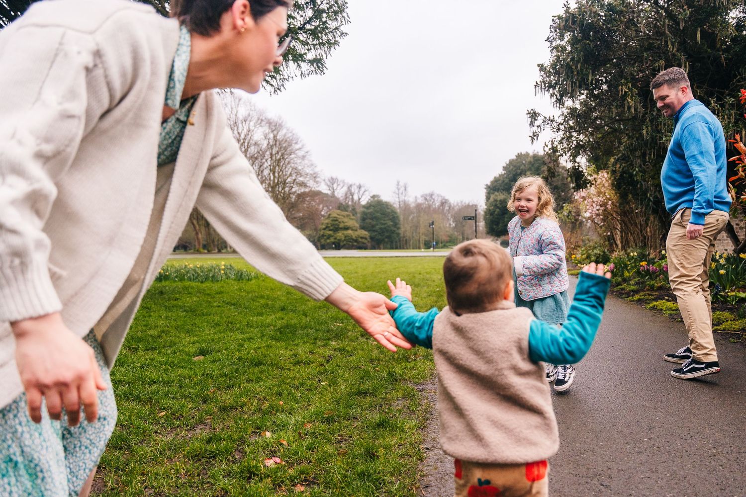 Two people hold hands and walk together along a countryside path on a misty autumn day.Family photographer Dublin Ireland