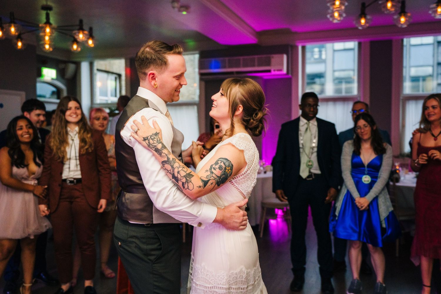 Couple shares an intimate dance moment under purple lighting at their wedding reception. PHOTOGRAPHER Dublin Ireland Wedding