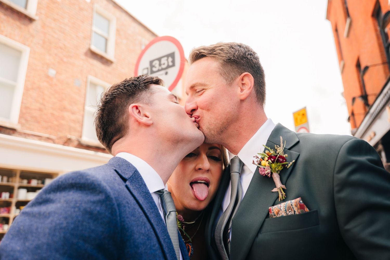 Three people sharing a fun moment together on a city street. Same sex wedding PHOTOGRAPHER Dublin