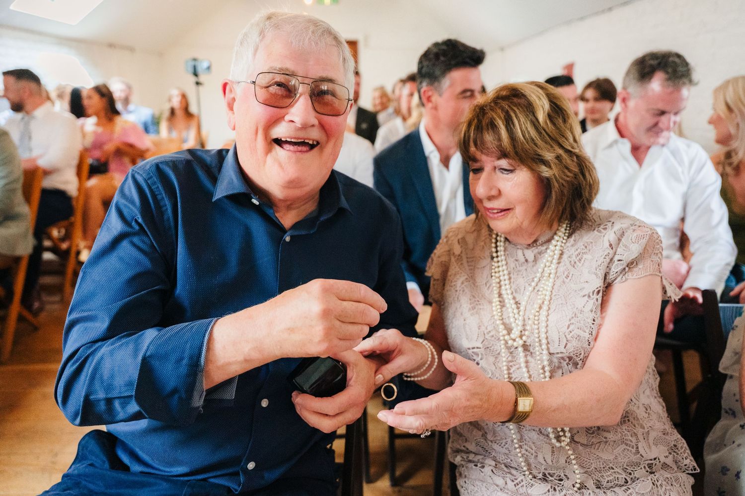 Two guests share a joyful moment while dancing and laughing together during a lively celebration. Same sex wedding PHOTOGRAPHER Dublin