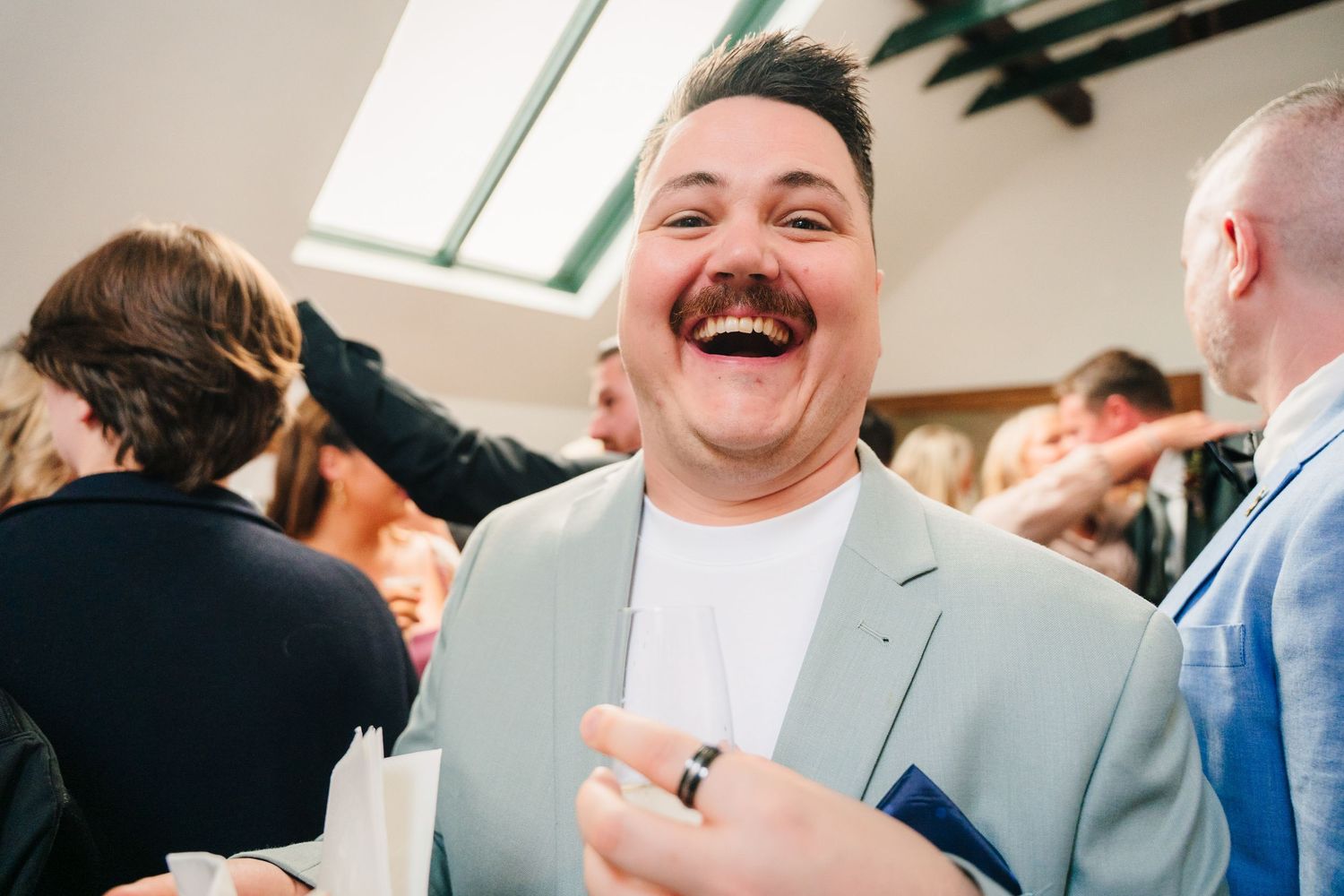Candid moments of guests laughing and celebrating at an indoor wedding reception. Same sex wedding PHOTOGRAPHER Dublin