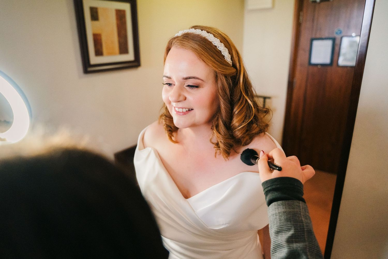 Bridal preparation scene showing the final touches before the ceremony begins.  Wedding PHOTOGRAPHER Trim Castle