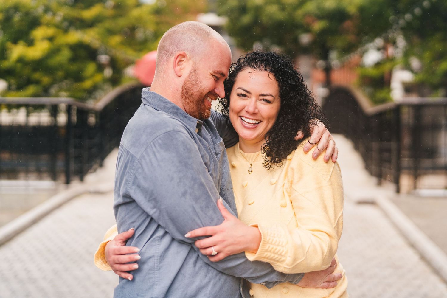 A couple embraces and laughs together while wearing casual clothing on an autumn day. Proposal Dublin Photographer