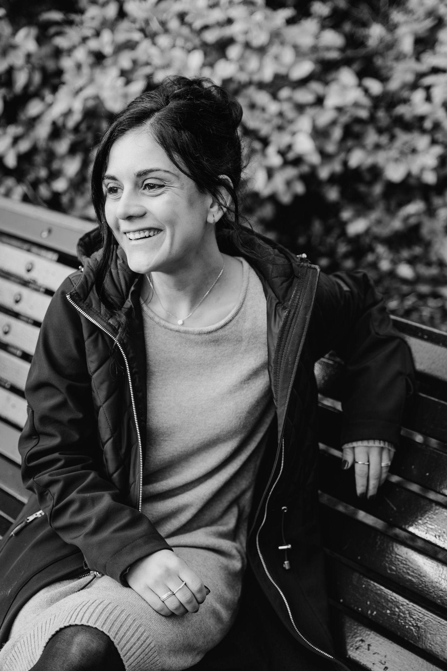 Black and white photo sequence showing someone seated on a park bench wearing a dark jacket and light sweater. professional headshots dublin