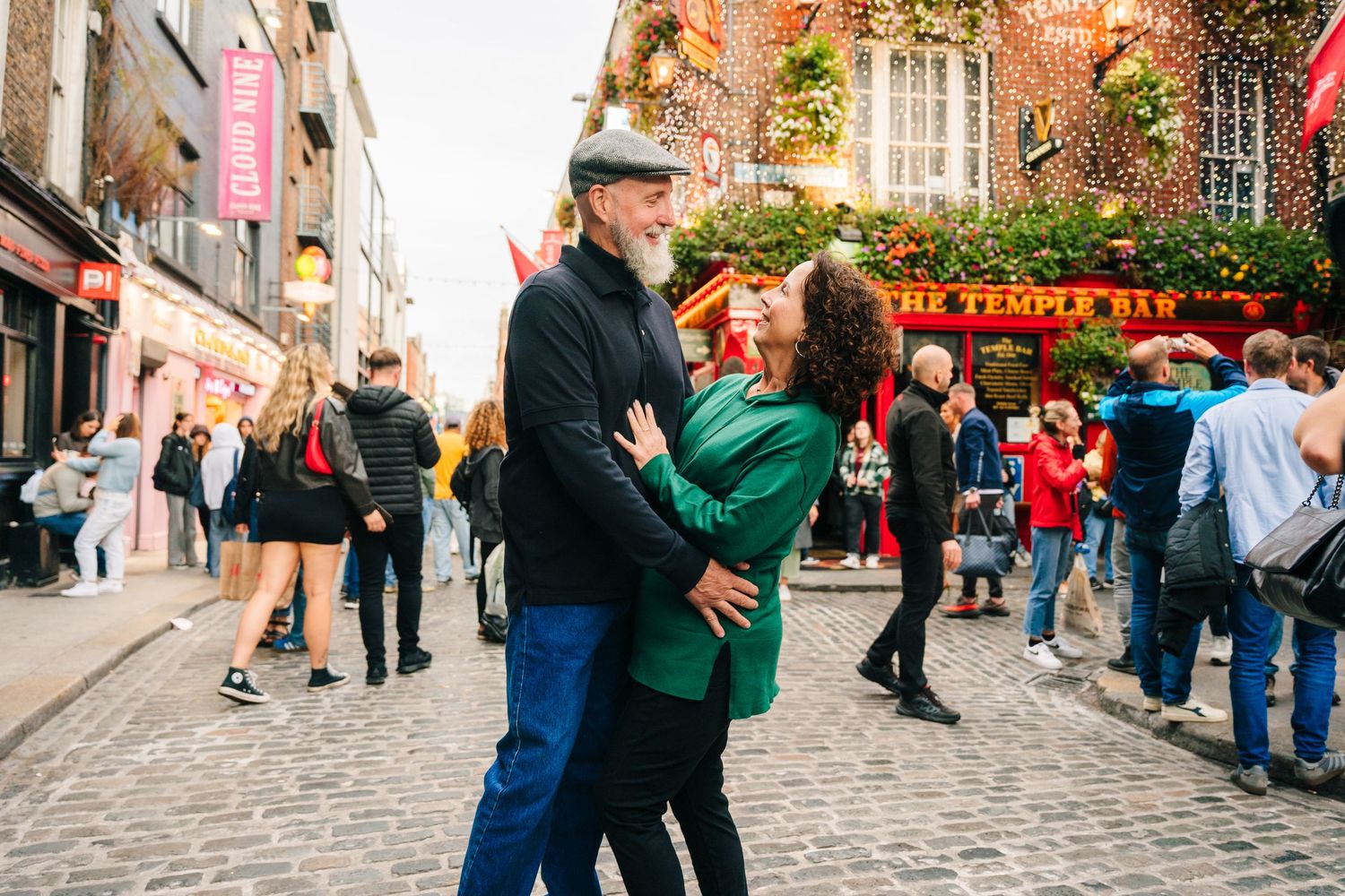 Couple shares a romantic moment outside the iconic Temple Bar in bustling Dublin, Ireland. Photographer dublin ireland