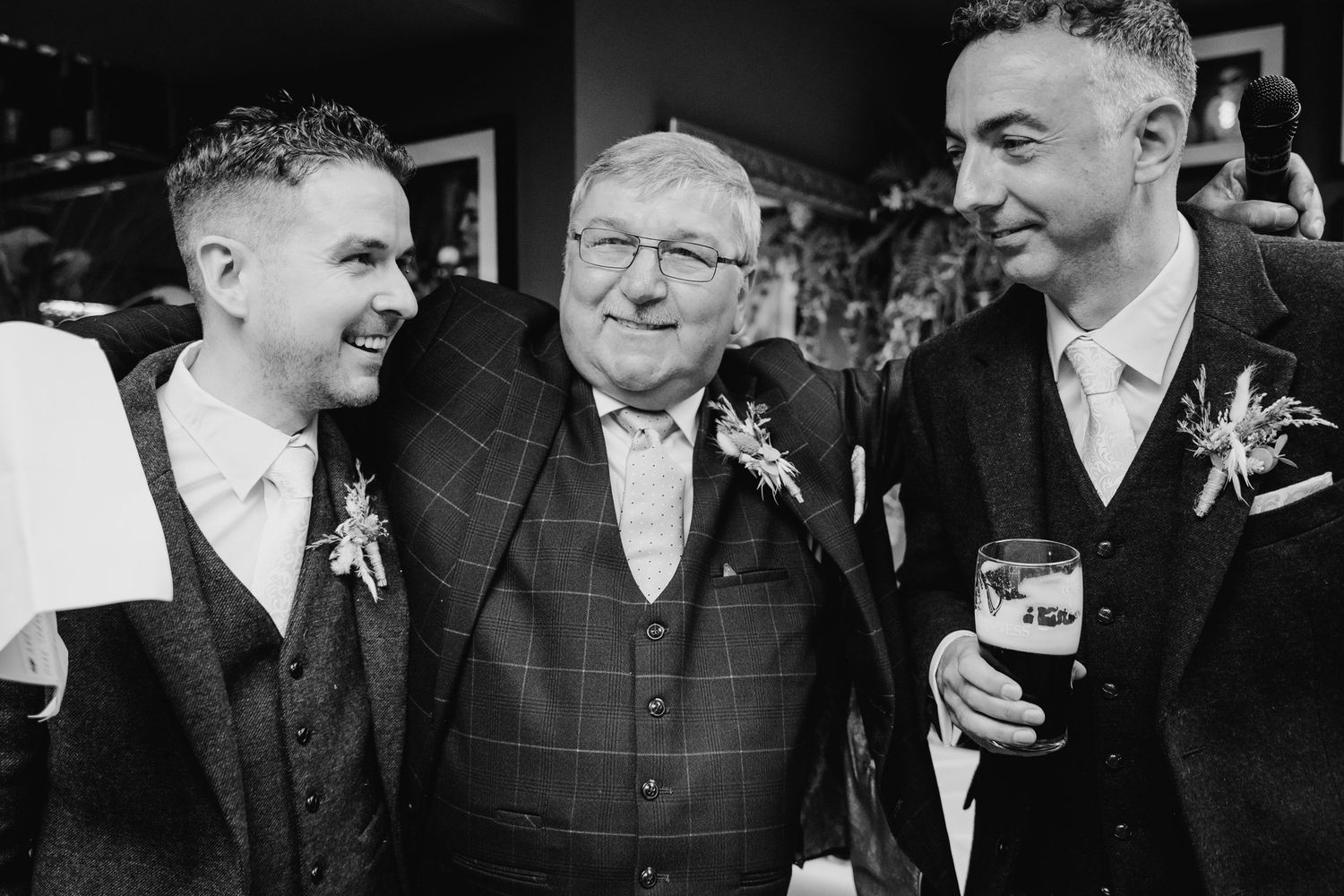 Black and white photo of guests sharing drinks and conversations at a wedding celebration. Marco Pierre Dublin Wedding Photographer
