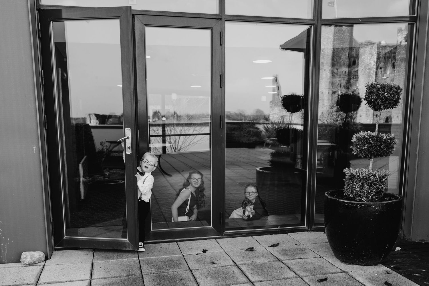 Panoramic black and white image of a modern open office interior with glass walls and views of a waterfront.  Wedding PHOTOGRAPHER Trim Cast