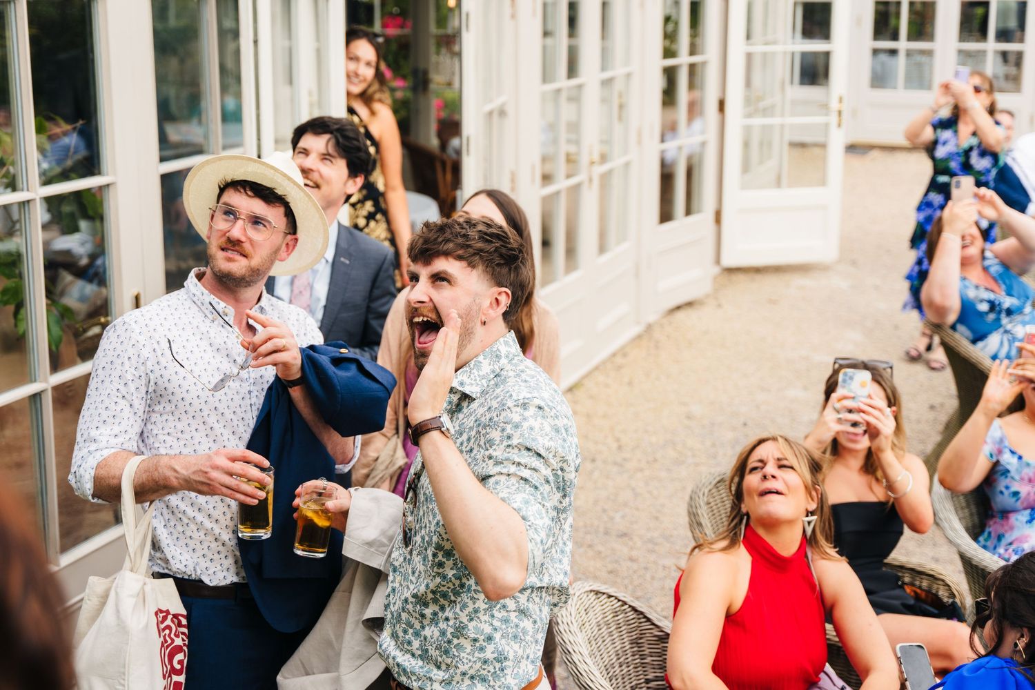 Millhouse slane wedding photographer dublin Wedding reception guests enjoying celebration in bright conservatory setting.