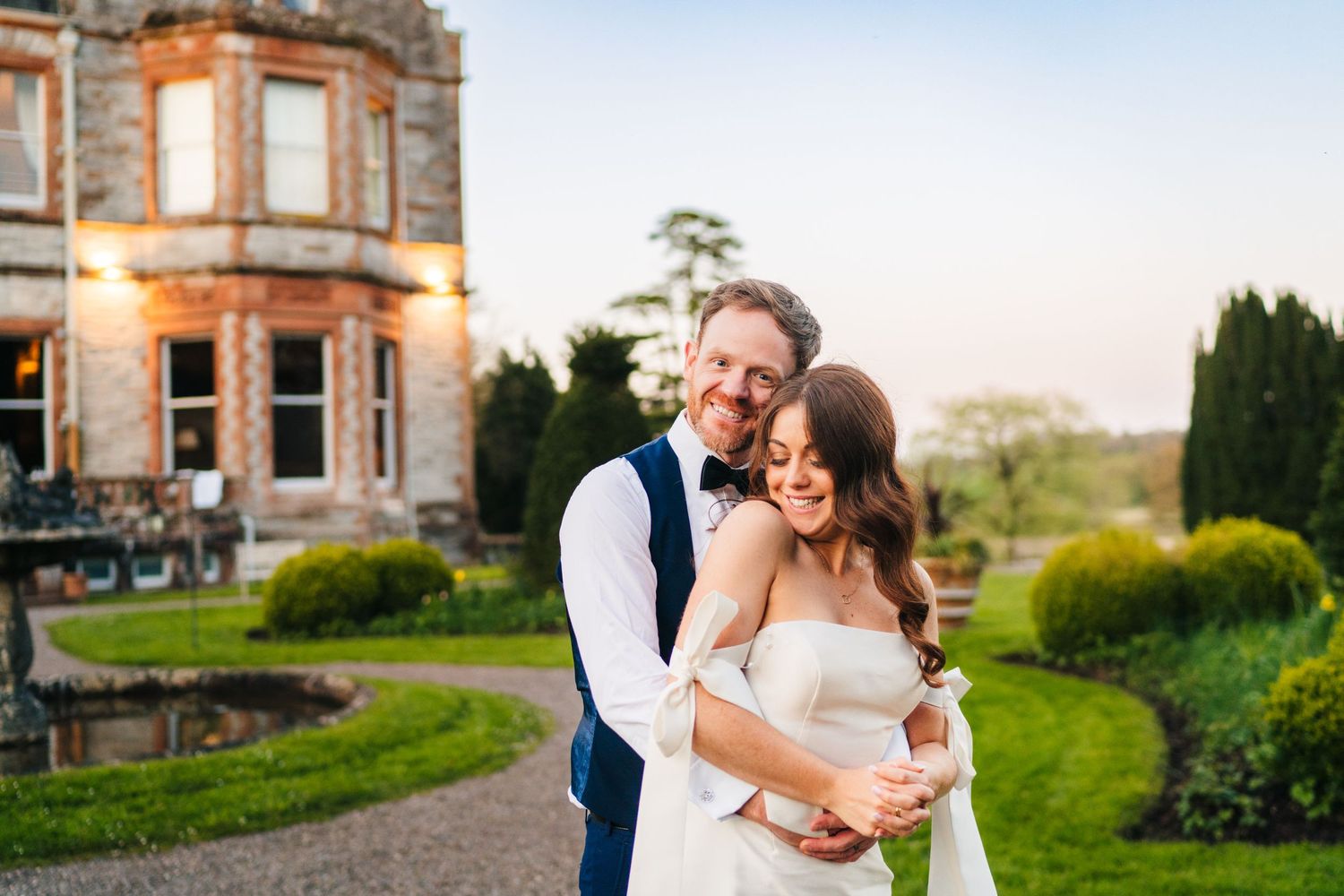 Castle Leslie Wedding Photographer Dublin Romantic wedding couple portraits at sunset in front of a grand stone estate building.