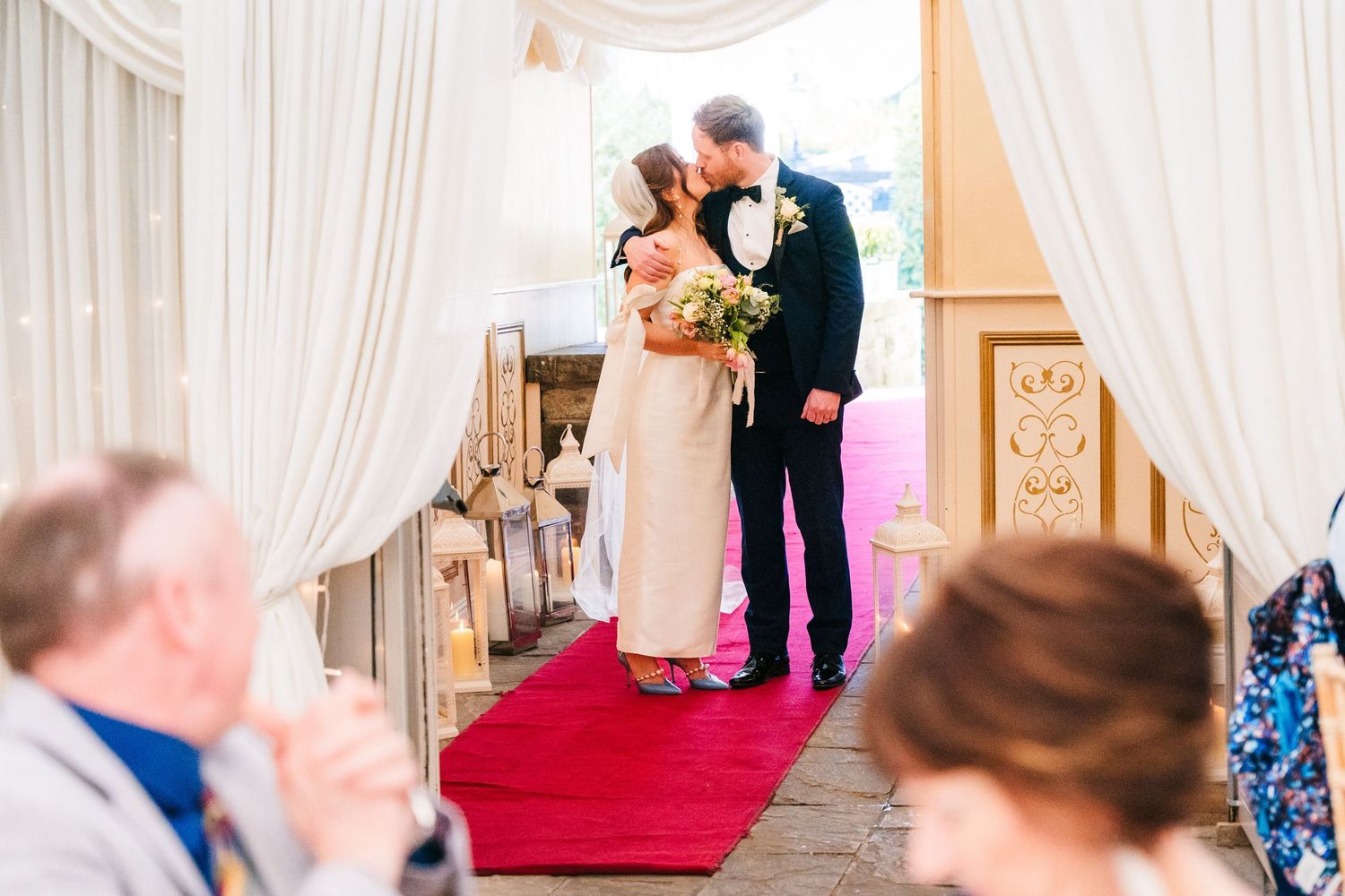 Castle Leslie Wedding Photographer Dublin Indoor wedding ceremony in an elegant white-draped venue with red carpet aisle.
