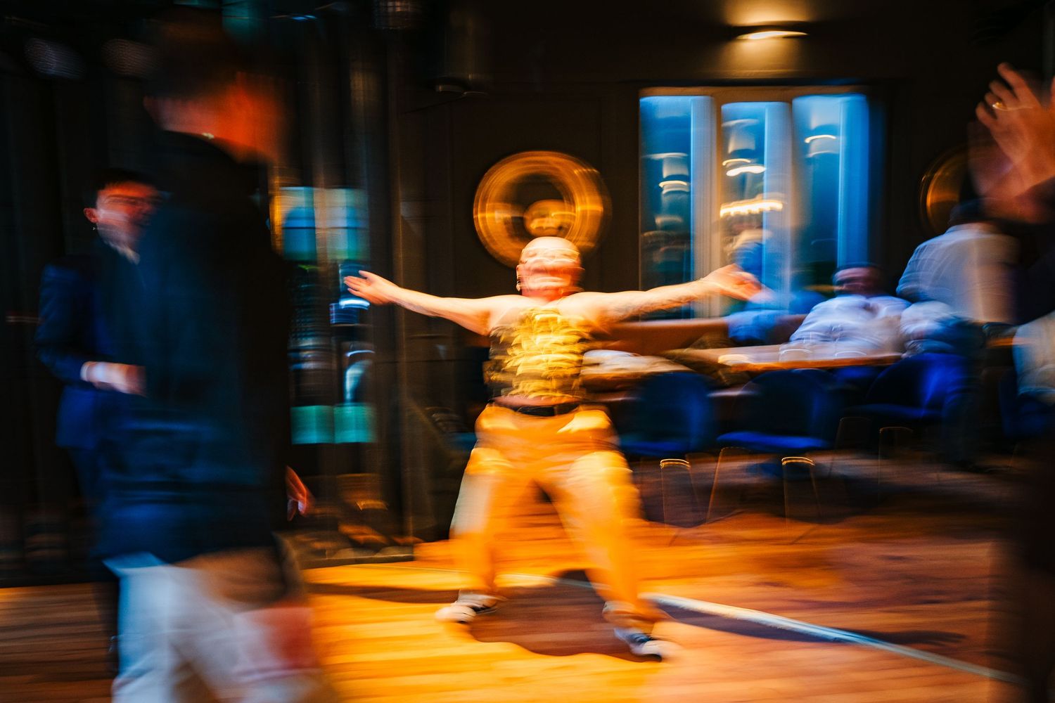 Poulaphouca Wedding photographer wicklow  A motion-blurred figure dances with outstretched arms on an illuminated dance floor.