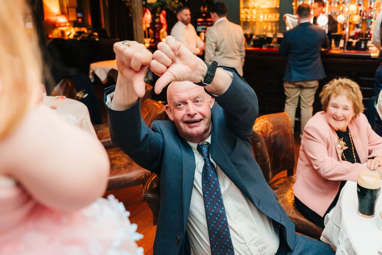 Warm-toned candid photos of guests enjoying evening celebration. Marco Pierre Dublin Wedding Photographer