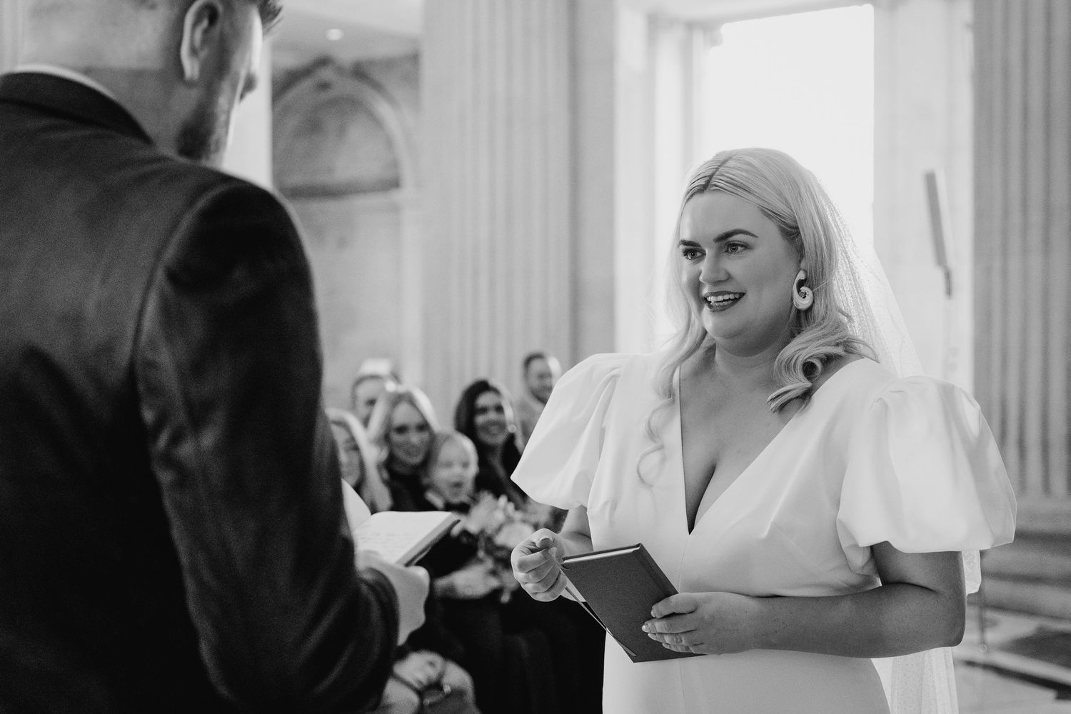 A wedding ceremony takes place in an elegant white-columned venue. Wedding photographer dublin