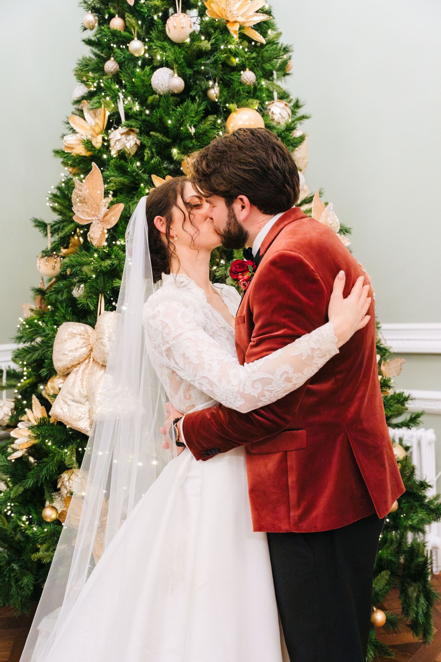 A romantic Christmas wedding moment in front of a decorated tree with peach and white decor. Stephens green club dublin Wedding photographer