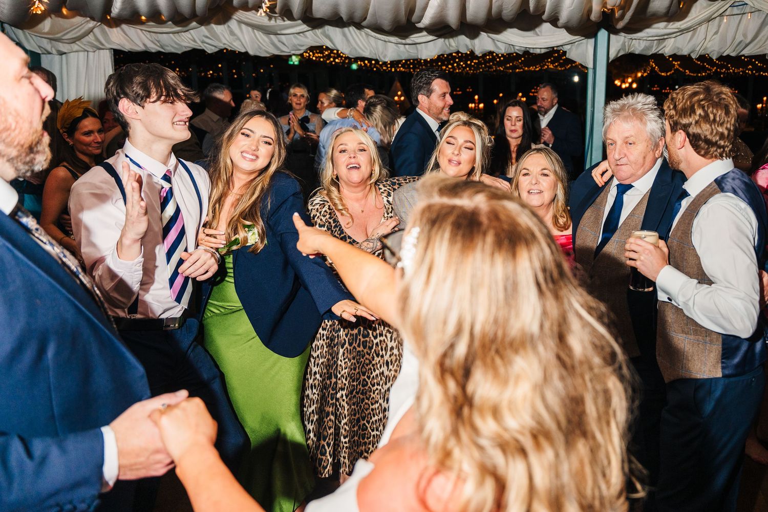 Wedding reception guests dancing and celebrating on a crowded dance floor.  Virginia Park Lodge Wedding Photographer Cavan Dublin Ireland