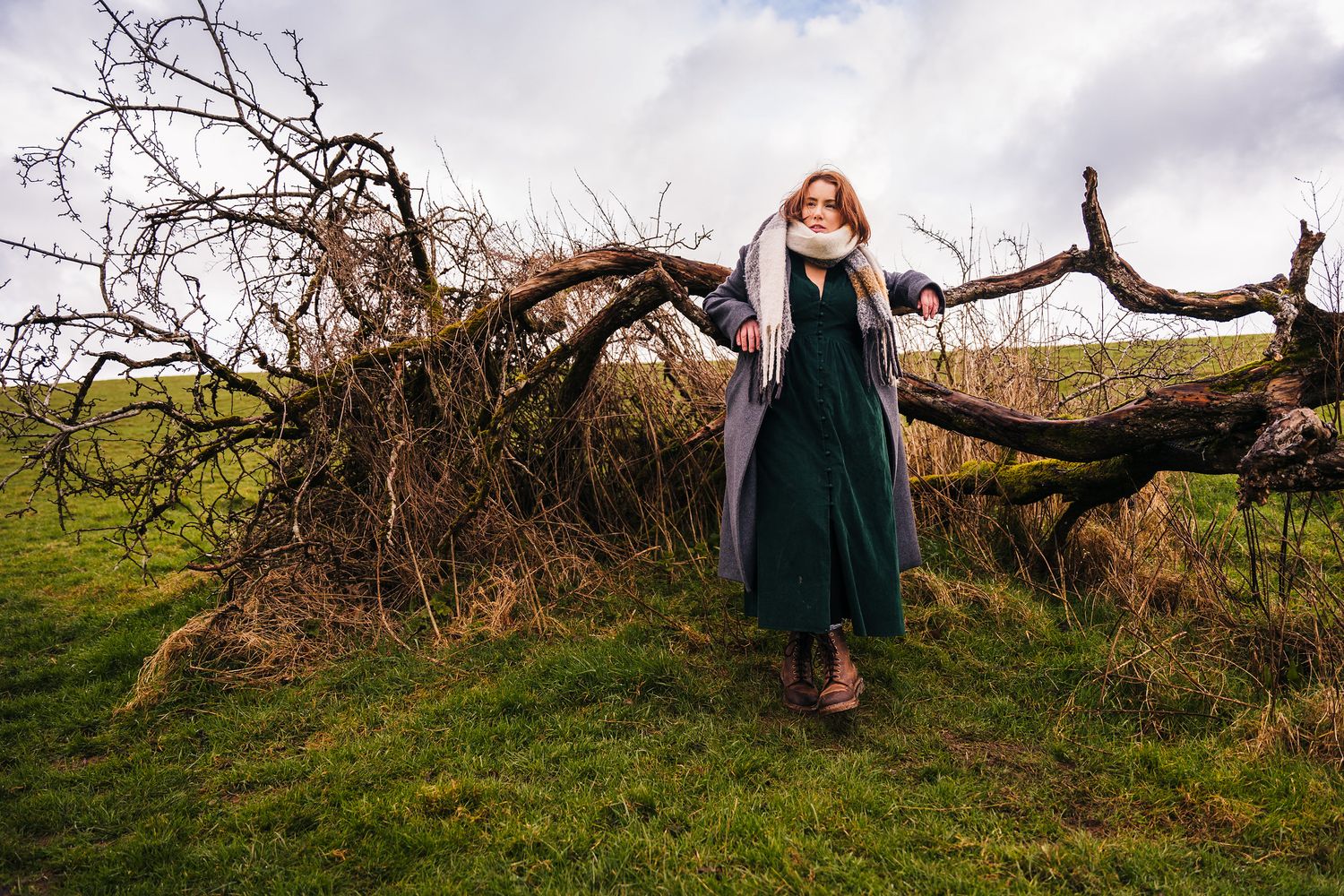 Long abandoned tree trunk laying in grassy field creates rustic outdoor portrait setting against cloudy sky. PHOTOGRAPHER Dublin ireland