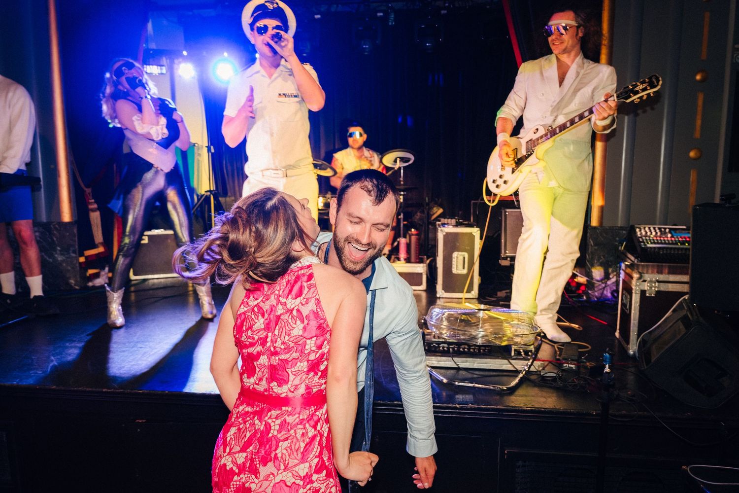 Live band performing on stage with blue stage lighting creating an energetic atmosphere. Wedding ceremony at the Set Theatre Langtons Hotel