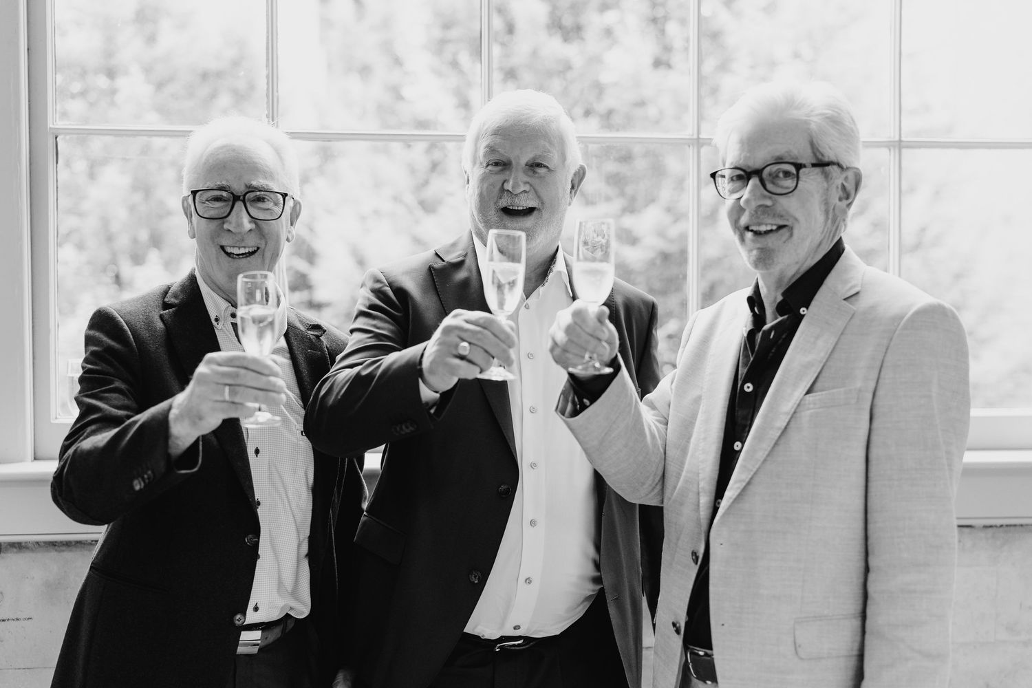 Joyful group laughs together at a formal event in black and white photography.  city hall dublin wedding photos