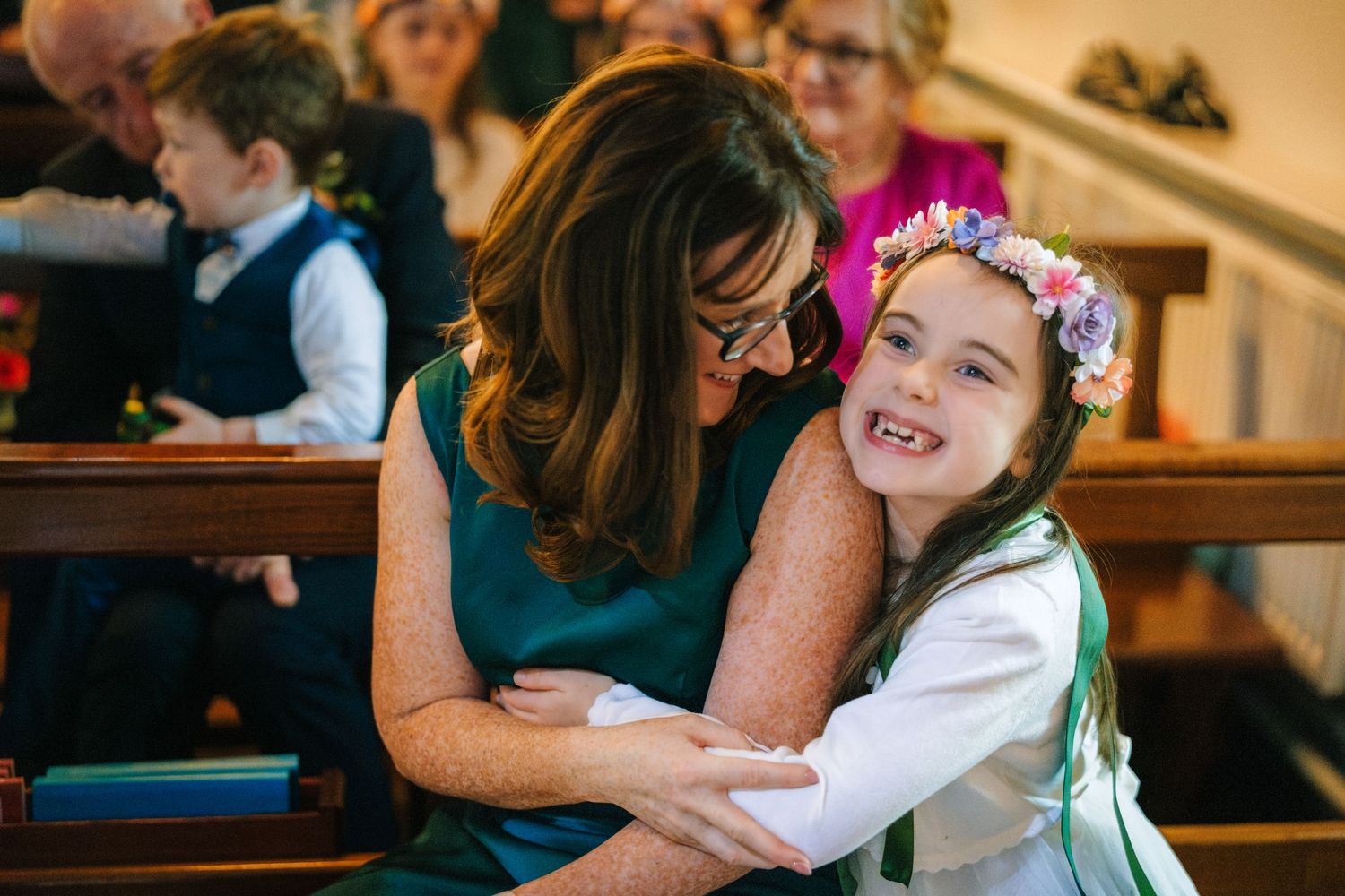 Children and adults share heartfelt hugs and embraces during a wedding celebration.