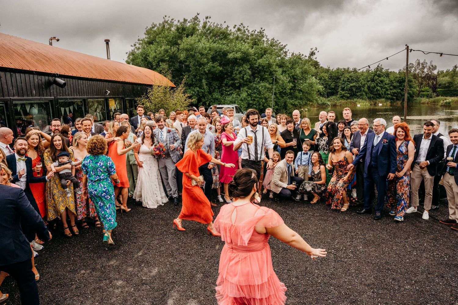 Wedding guests dancing and celebrating on an outdoor patio area during reception. Wedding photographer Dublin