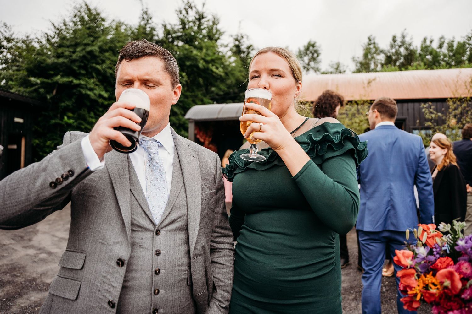 Wedding guests toasting and celebrating outdoors at a garden reception. Wedding photographer Dublin