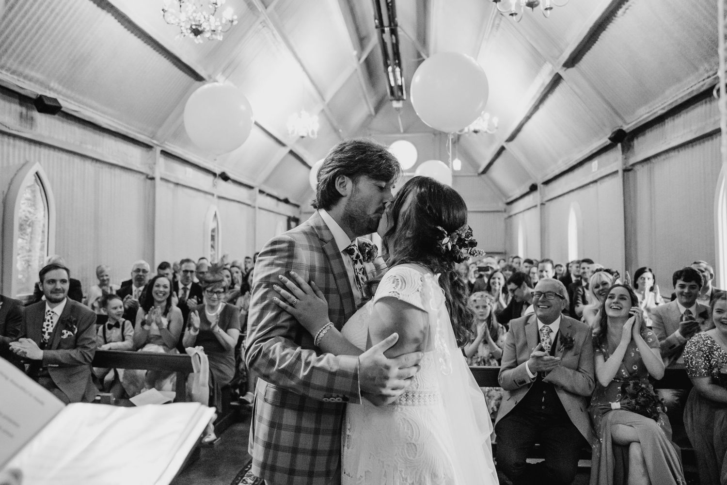 Black and white photos showing a lively dance floor celebration with guests dancing and cheering. Wedding photographer Dublin