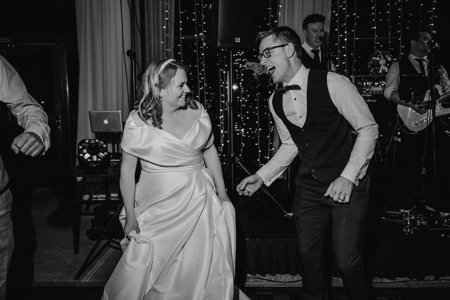 Wedding party dancing and celebrating in front of a sparkly light curtain backdrop.  Wedding PHOTOGRAPHER Trim Castle