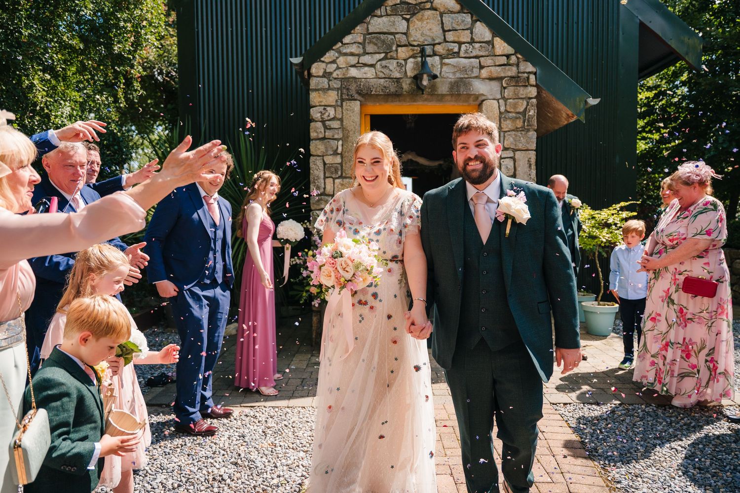 Guests gathered outdoors at a rustic stone building venue for a wedding celebration. . Village Barn Tyrrellspass wedding photographer Irelan