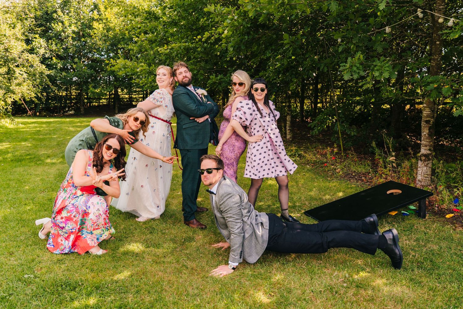 Wedding guests relaxing on grass during outdoor summer celebration. . Village Barn Tyrrellspass wedding photographer Ireland